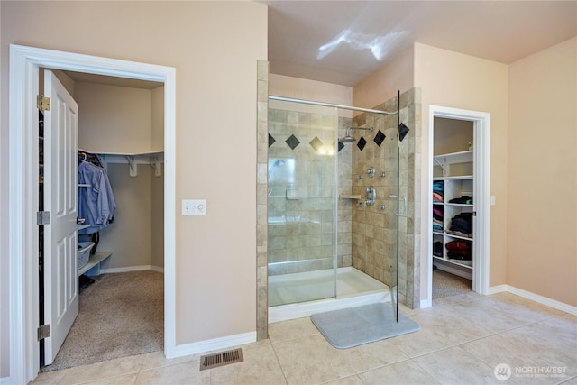 full bath featuring baseboards, a stall shower, visible vents, and tile patterned floors