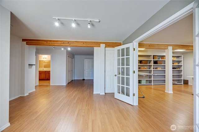 spare room with baseboards, french doors, and light wood-style floors