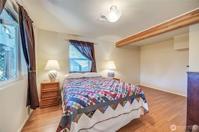 bedroom with visible vents, light wood-style flooring, and baseboards