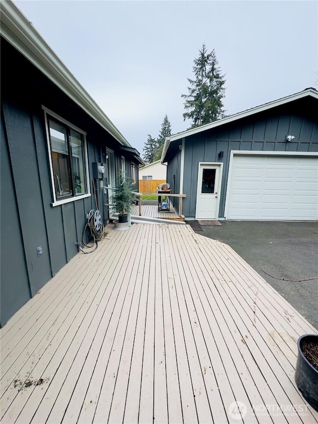 wooden deck featuring a garage and area for grilling