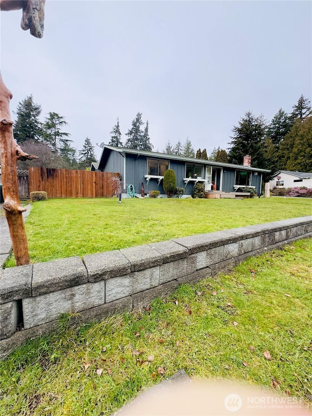 view of front of property featuring a front yard and fence