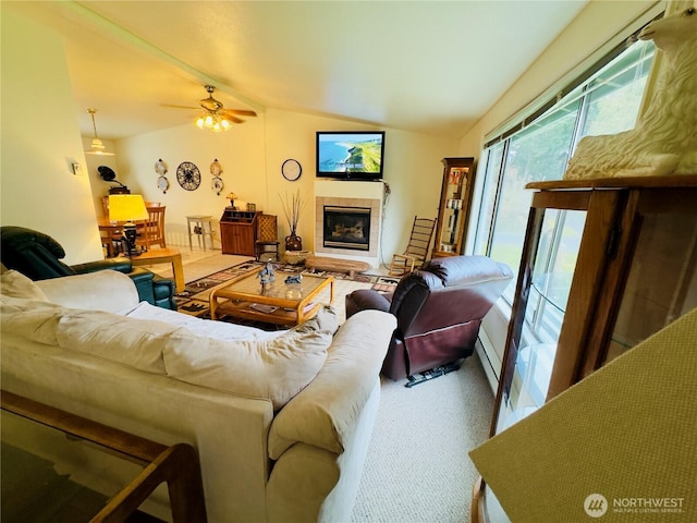 living area with lofted ceiling, carpet floors, ceiling fan, and a tiled fireplace