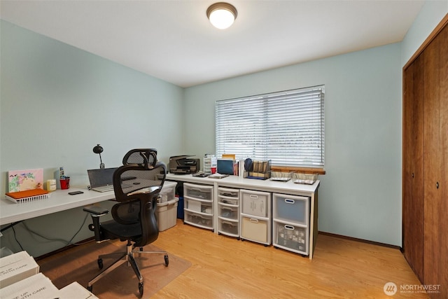 office space with light wood-type flooring and baseboards