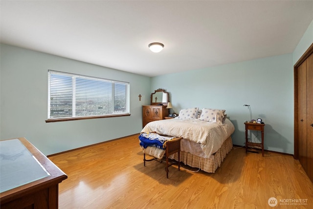 bedroom with light wood finished floors and baseboards