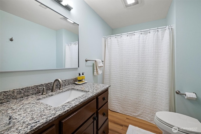 full bathroom with vanity, toilet, and wood finished floors