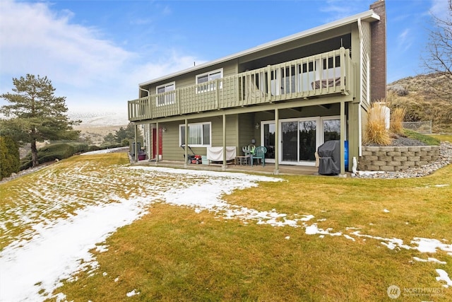 rear view of property with a patio area, a chimney, and a lawn