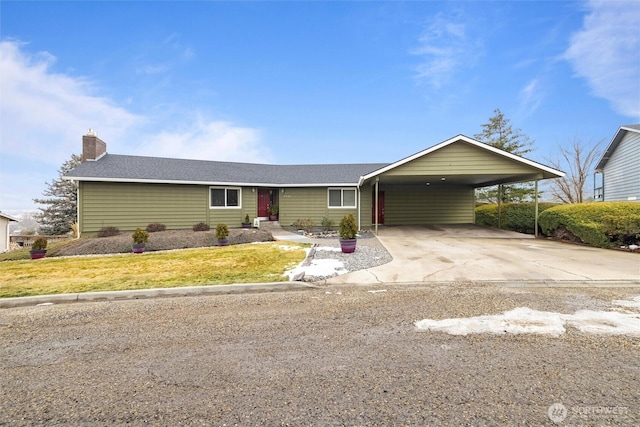 ranch-style house featuring a carport, driveway, a front lawn, and a chimney