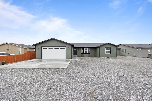 ranch-style home featuring a garage, concrete driveway, fence, and stucco siding