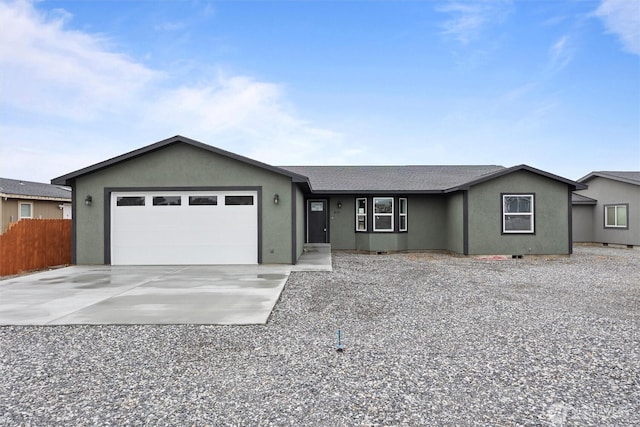 single story home with an attached garage, fence, concrete driveway, roof with shingles, and stucco siding