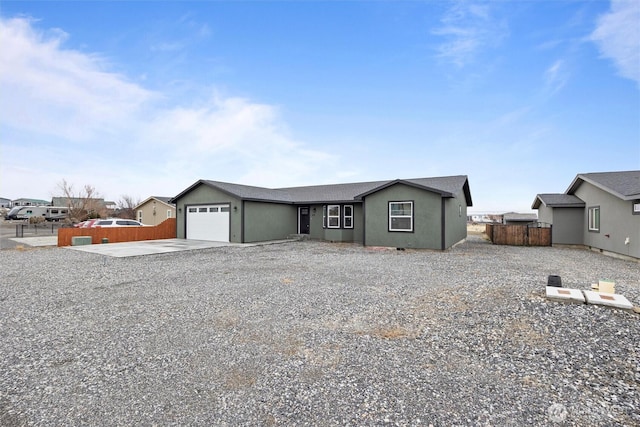 view of front facade with a garage, concrete driveway, and fence