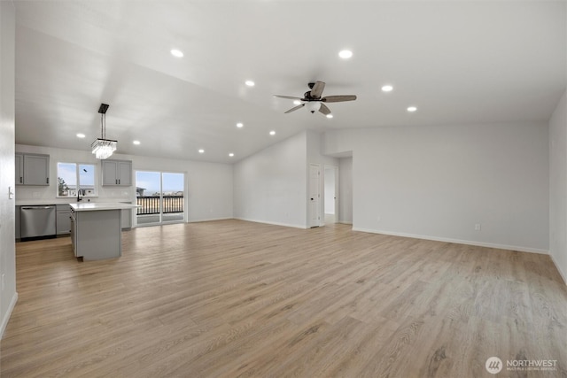 unfurnished living room with recessed lighting, vaulted ceiling, ceiling fan, a sink, and light wood-type flooring