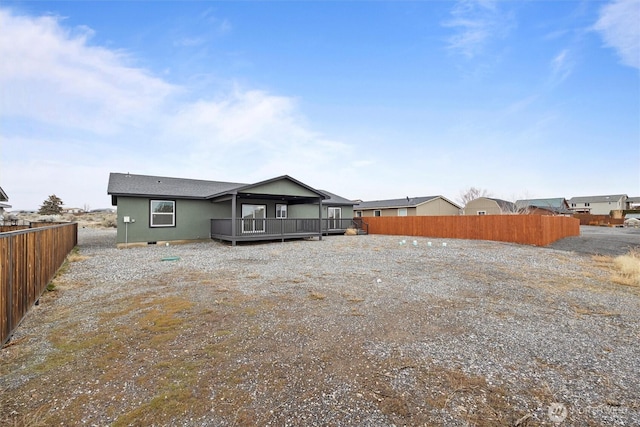 rear view of house with fence and a wooden deck