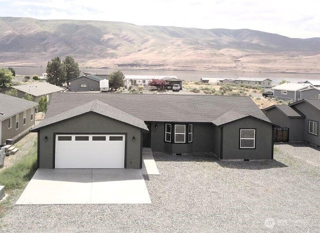 ranch-style house with concrete driveway, a mountain view, an attached garage, and stucco siding