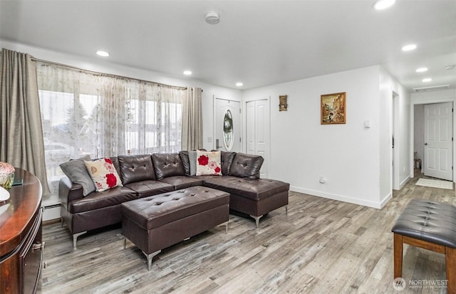 living area featuring a baseboard radiator, baseboards, light wood finished floors, and recessed lighting