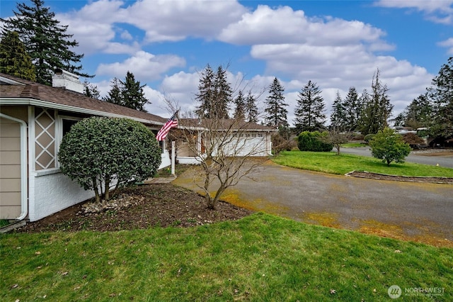 view of yard featuring a garage and driveway