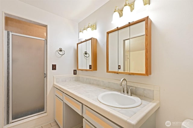 bathroom with a shower stall and vanity