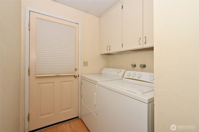 clothes washing area with cabinet space, independent washer and dryer, and light wood-type flooring