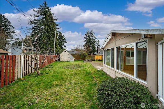 view of yard with a storage unit, an outdoor structure, a fenced backyard, and a sunroom