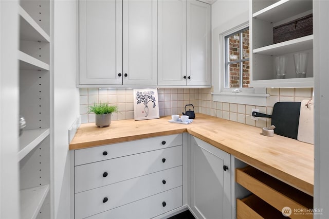 interior space featuring wood counters, white cabinetry, open shelves, and backsplash