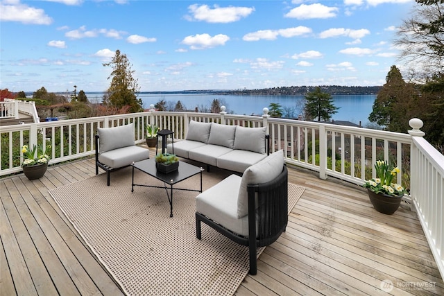 wooden deck with a water view and outdoor lounge area