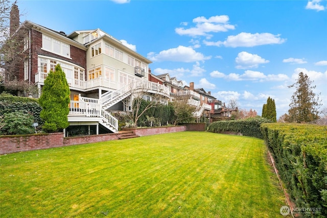 view of yard featuring stairs, fence, a deck, and a residential view