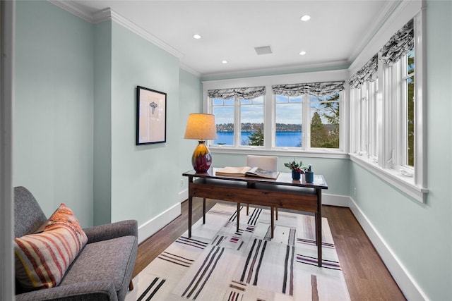 office space featuring a water view, wood finished floors, and baseboards