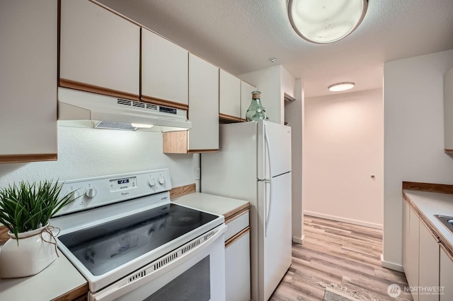 kitchen featuring light countertops, a textured ceiling, light wood-type flooring, white appliances, and under cabinet range hood