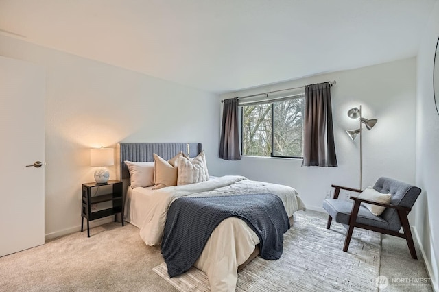 bedroom with light colored carpet and baseboards