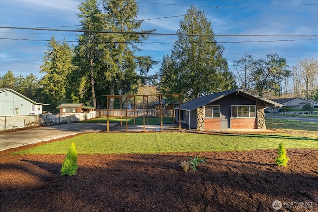 view of front of house featuring brick siding, a front yard, and fence