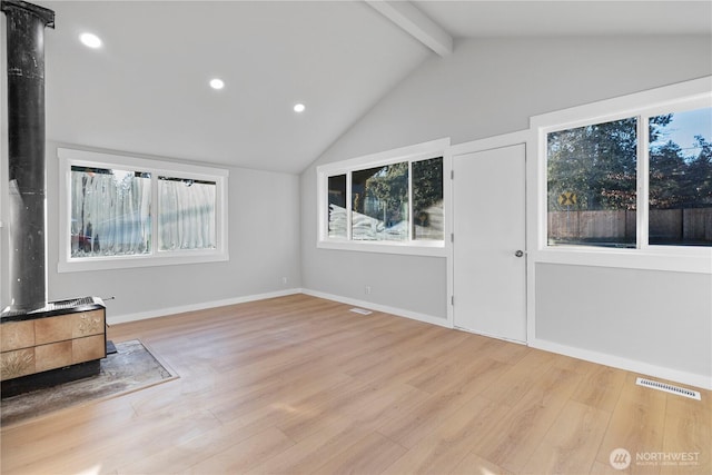 unfurnished living room featuring lofted ceiling with beams, light wood-style flooring, and visible vents