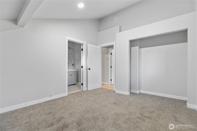 unfurnished bedroom with baseboards, light colored carpet, ensuite bathroom, vaulted ceiling, and recessed lighting