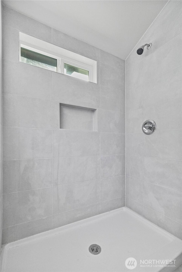 bathroom featuring a wealth of natural light and a tile shower