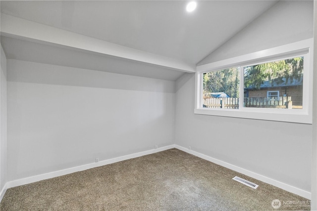 additional living space with lofted ceiling, baseboards, visible vents, and carpet flooring