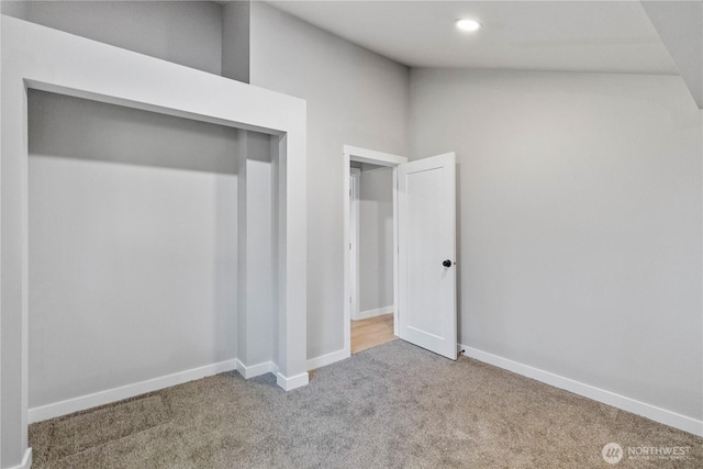 unfurnished bedroom featuring carpet floors, lofted ceiling, baseboards, and recessed lighting