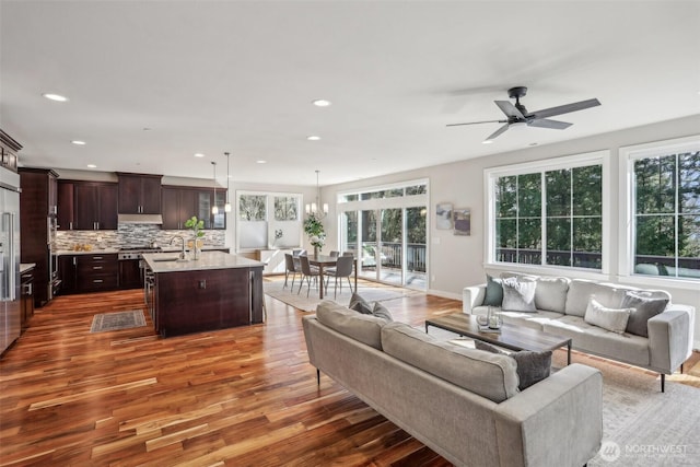 living area with baseboards, wood finished floors, a ceiling fan, and recessed lighting