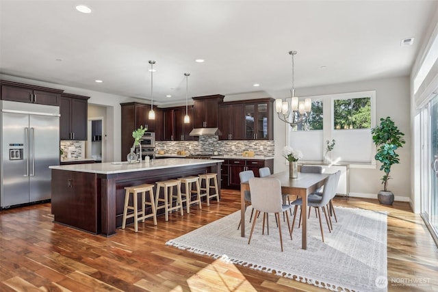 dining space with recessed lighting, dark wood-style flooring, visible vents, and a notable chandelier