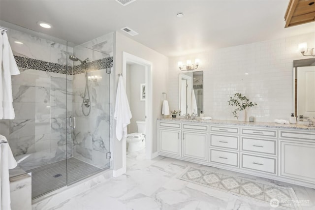 full bath featuring marble finish floor, a marble finish shower, double vanity, visible vents, and toilet