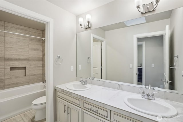 full bathroom with double vanity,  shower combination, a sink, and toilet