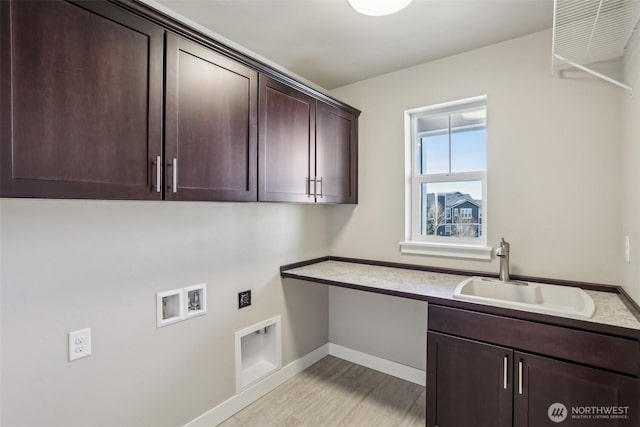 clothes washing area featuring cabinet space, baseboards, a sink, hookup for a washing machine, and electric dryer hookup