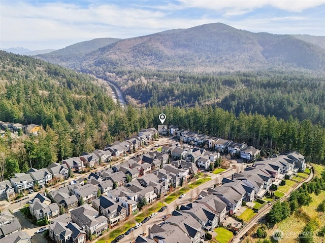 birds eye view of property with a residential view, a mountain view, and a view of trees