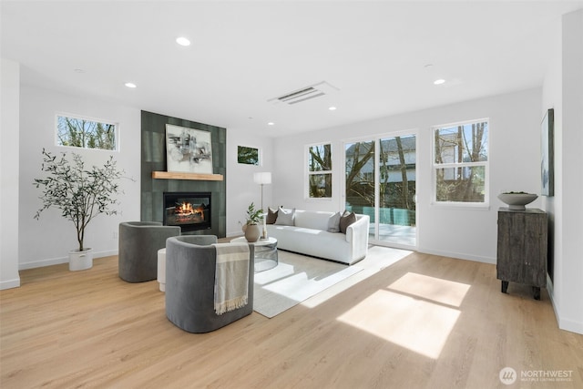 living area with a fireplace, visible vents, wood finished floors, and recessed lighting