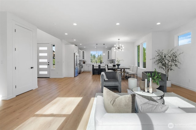 living area featuring plenty of natural light, light wood-type flooring, and recessed lighting