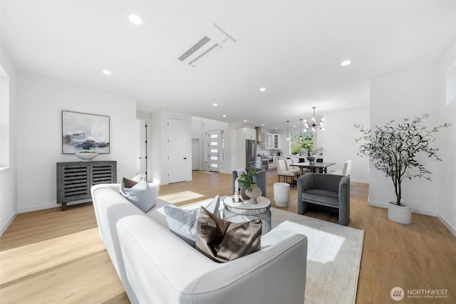 living area featuring recessed lighting, visible vents, light wood-style flooring, a chandelier, and baseboards