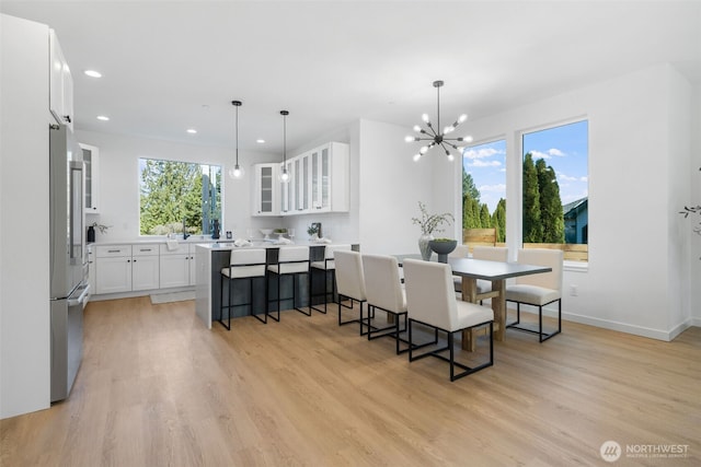 dining area with light wood finished floors, baseboards, a notable chandelier, and recessed lighting