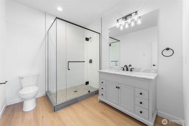 full bath featuring toilet, a stall shower, wood finished floors, and vanity