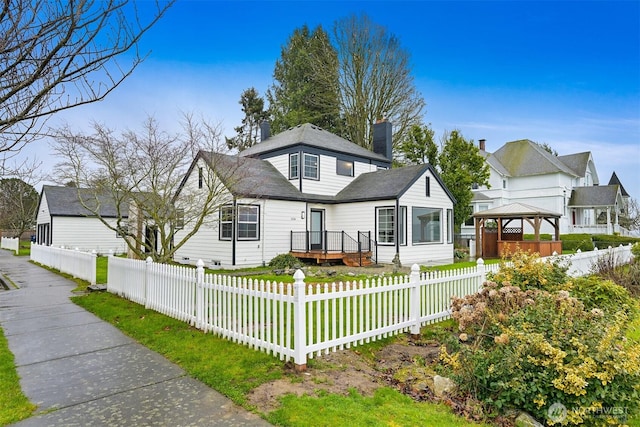 view of front facade with a gazebo, a fenced front yard, and a chimney