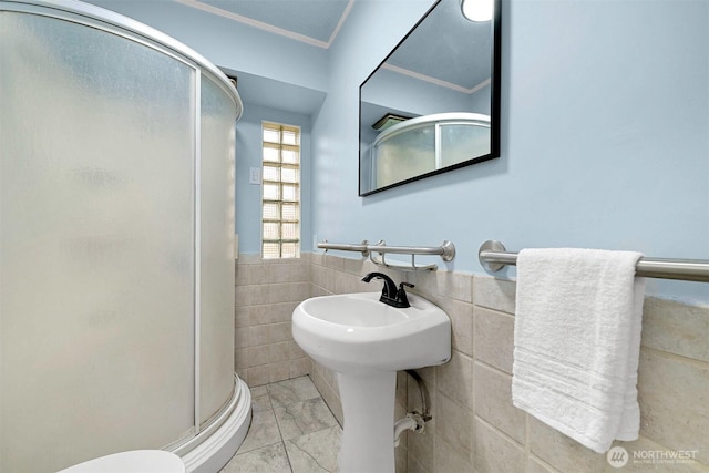 full bathroom featuring wainscoting, a shower stall, tile walls, and marble finish floor