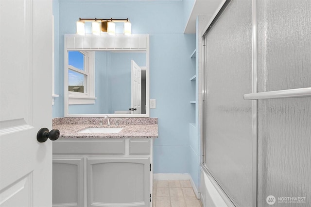 bathroom with vanity, baseboards, and a shower with shower door