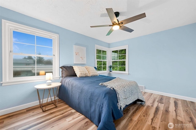 bedroom with wood finished floors, baseboards, and ceiling fan