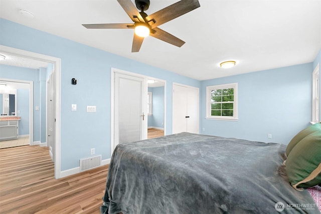 bedroom featuring visible vents, light wood-style flooring, baseboards, and ceiling fan